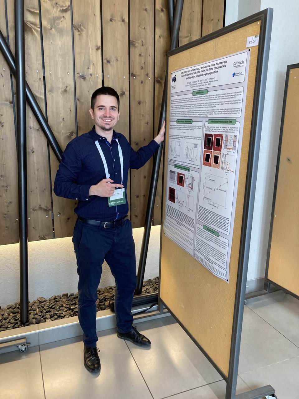 Stanko Nedić presenting his spectroscopy research beside a scientific poster